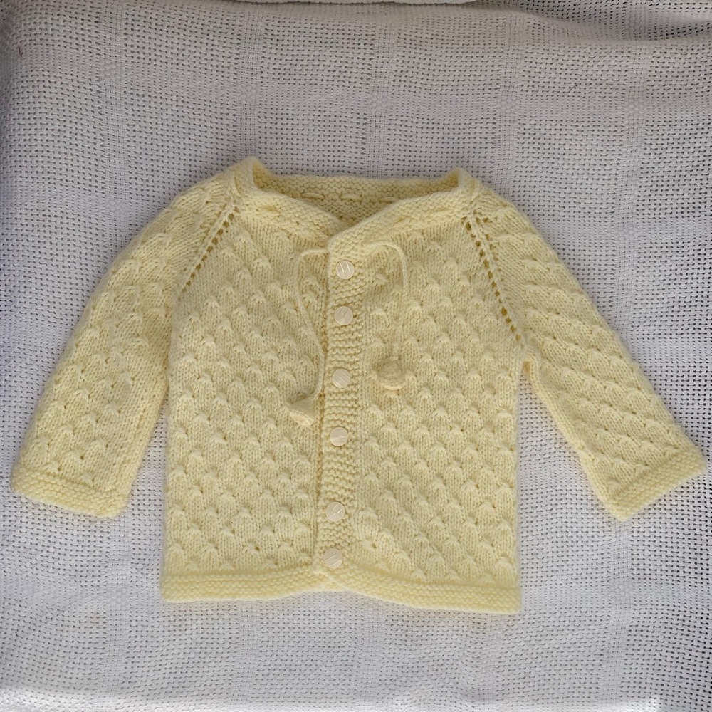 Hand knit sweater with belled tassels